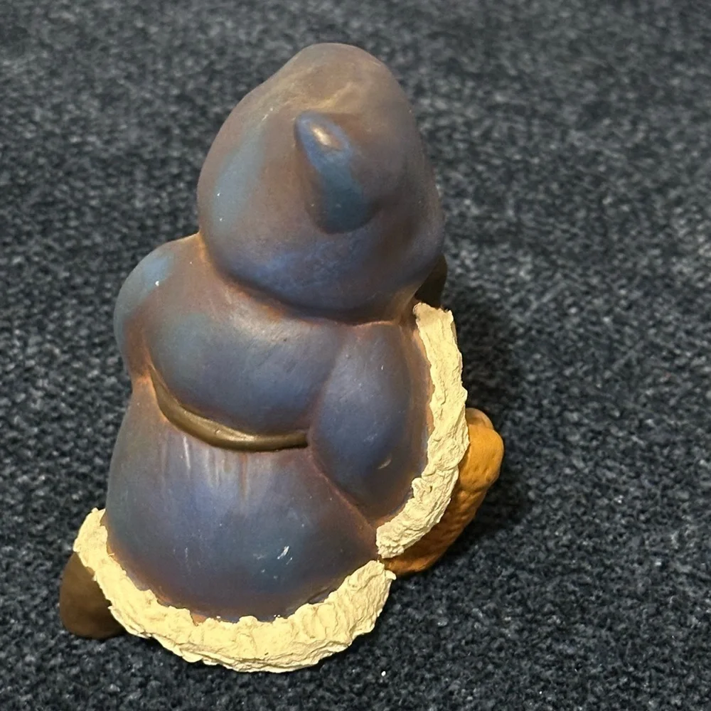 Cute blue robed kneeling Santa. He carries a basket of gifts.